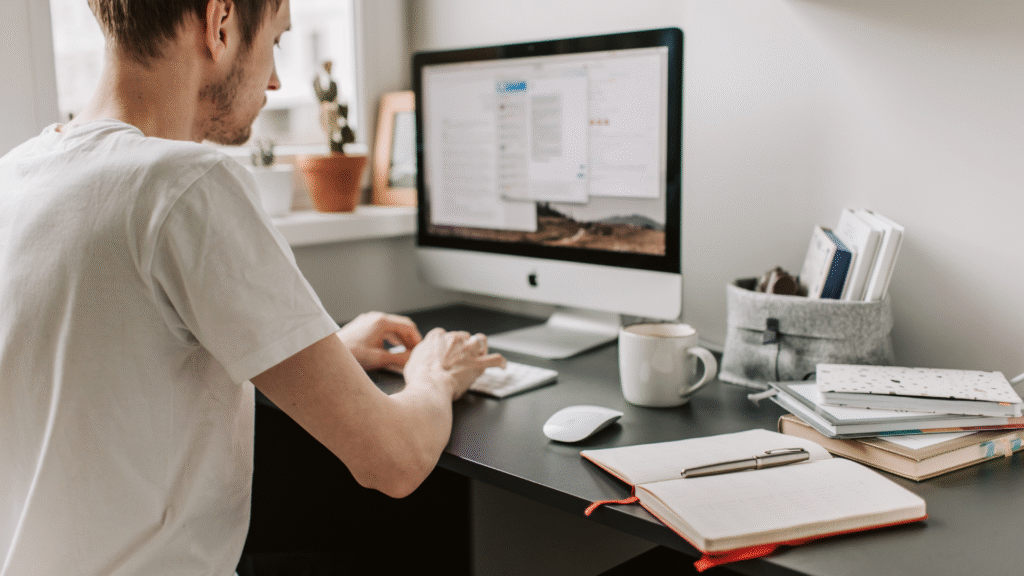Man on his computer, potentially struggling with accessing a website.